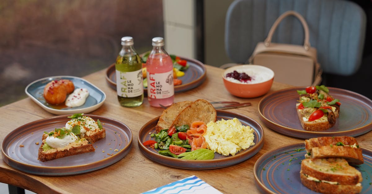 A variety of brunch dishes including salads, sandwiches, and beverages arranged on a wooden table.